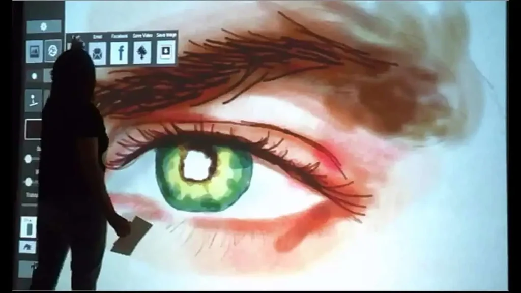 A person stands before a large digital screen displaying a detailed, colourful painting of a green eye with prominent eyelashes and eyebrow, while digital art tools suggest sketch bot hire for an engaging corporate event experiential atmosphere.